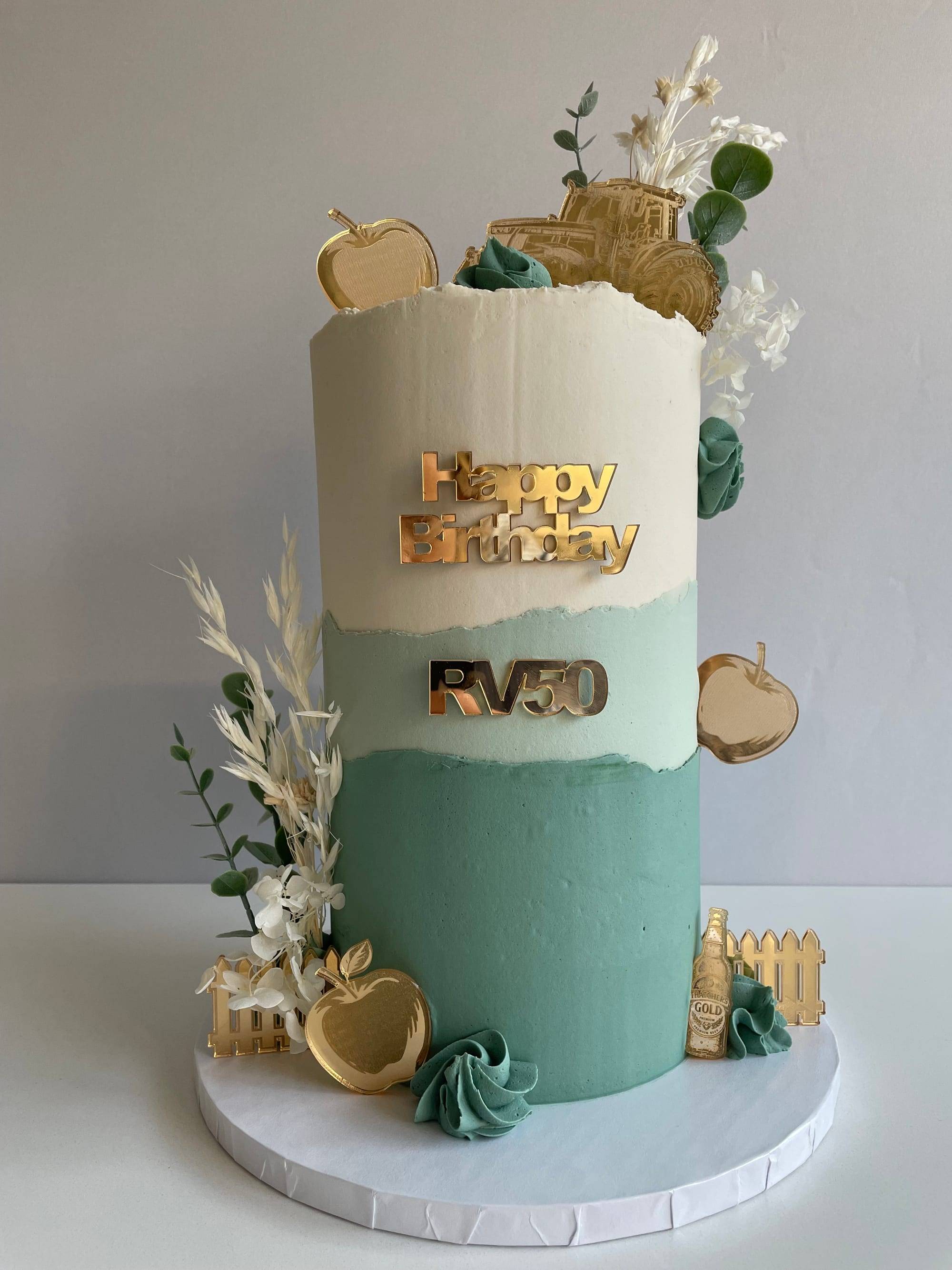 Farming-themed 50th birthday cake with cream-to-sage ombre buttercream and a gold tractor topper