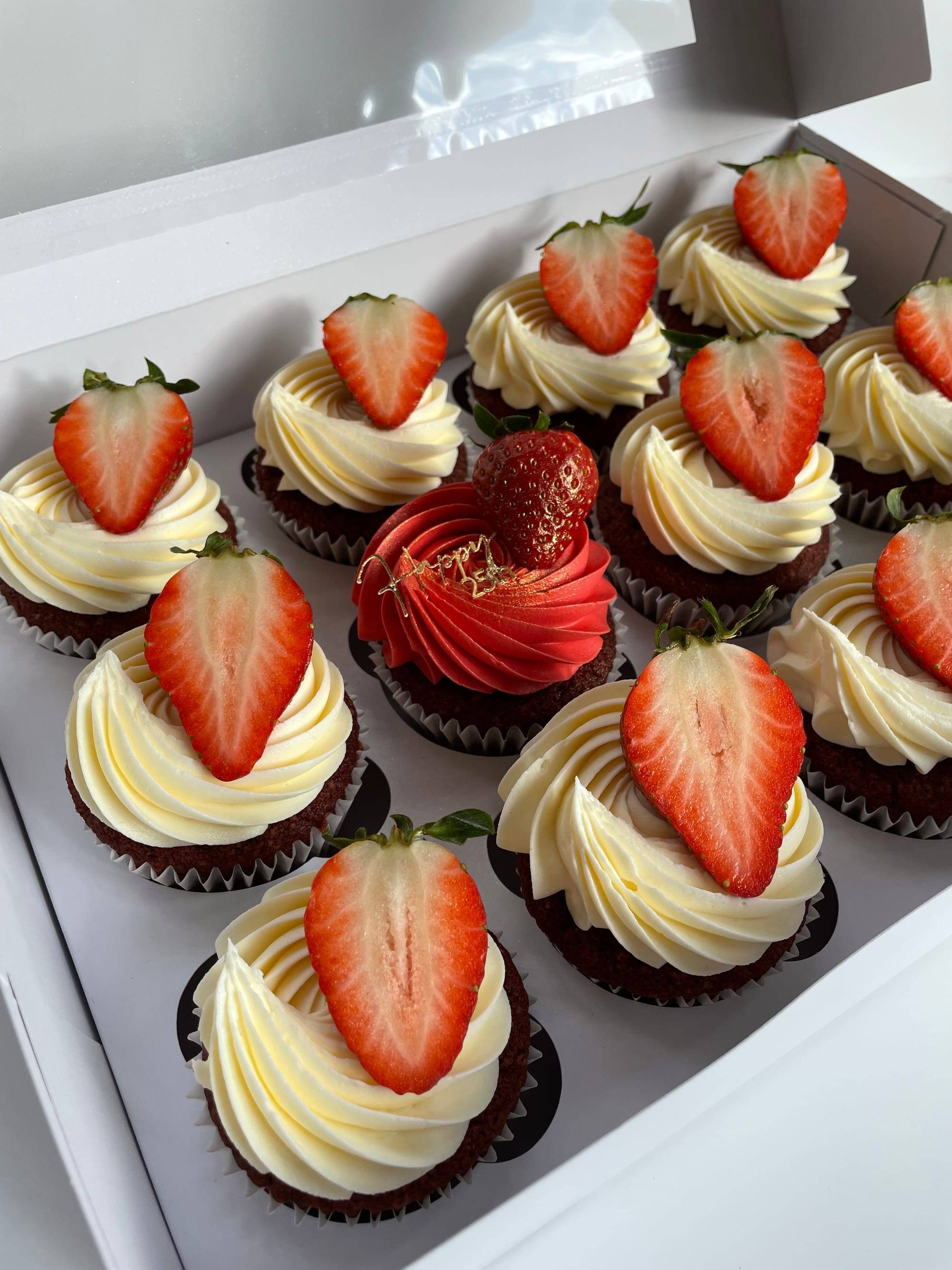 Strawberries and cream cupcakes with ivory swirled buttercream and halved fresh strawberries