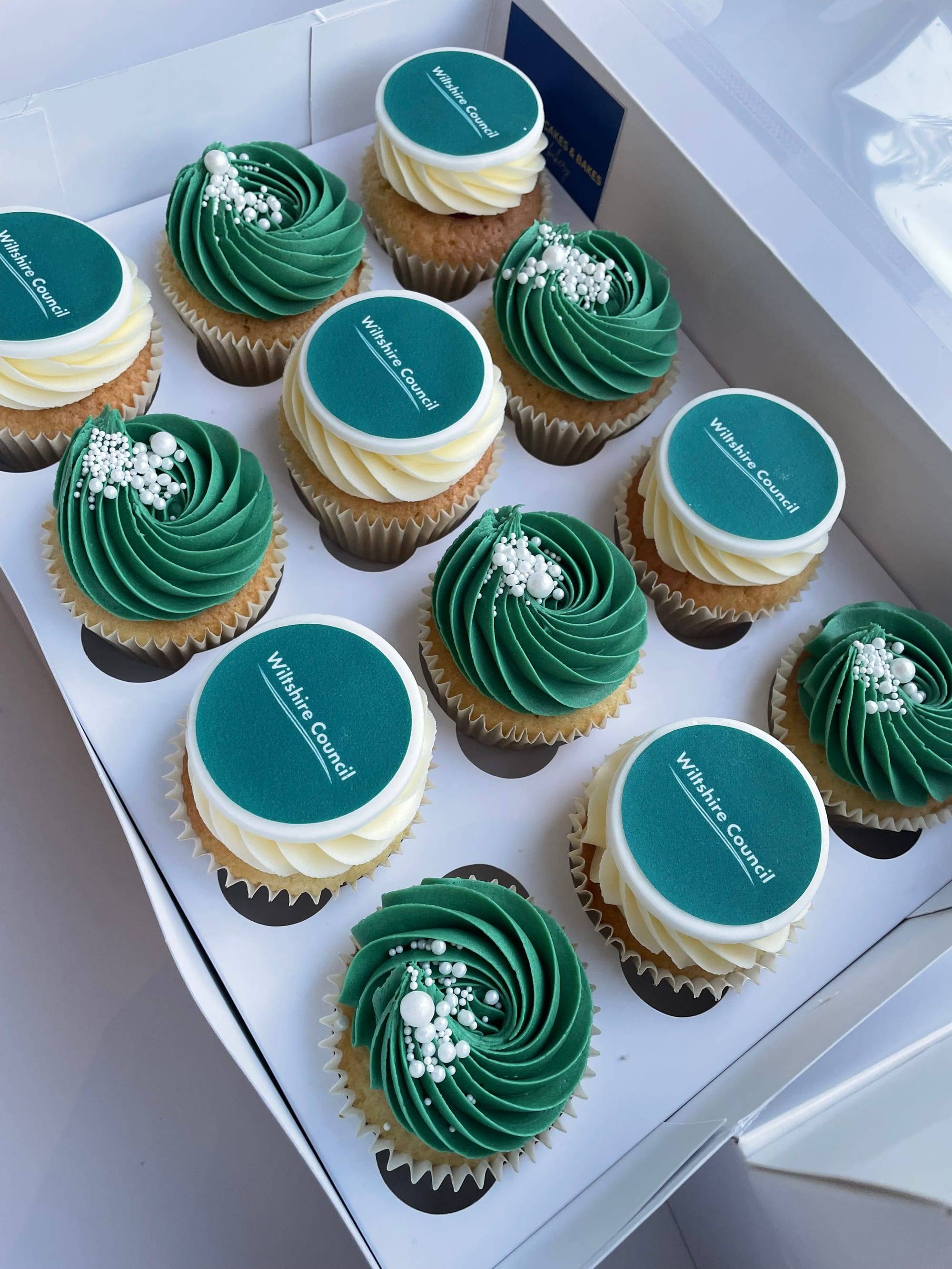 Corporate cupcakes with teal swirled buttercream and branded fondant toppers